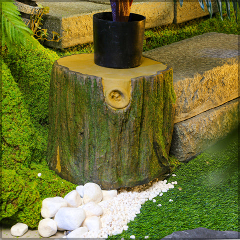 Faux mossy tree stump in landscaping